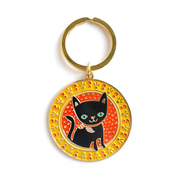 CUGLE adorable anime black cat keychain with blue eyes and scarf, set in orange dotted background with yellow floral border