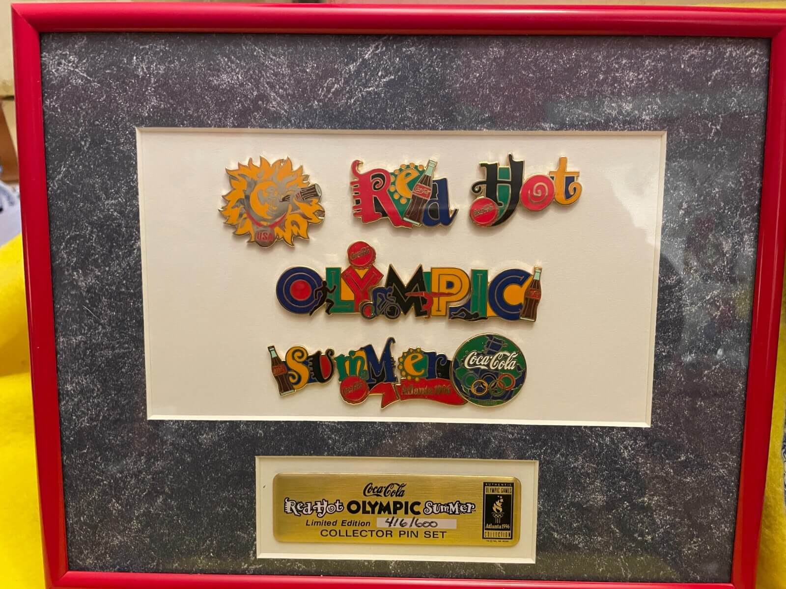 Framed Coca-Cola Olympic limited edition pin set titled “Red Hot Olympic Summer,” featuring vibrant enamel designs from Atlanta 1996.