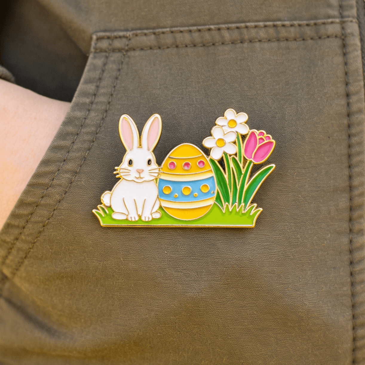  Easter custom lapel pin showing a bunny, yellow egg, and spring flowers on fabric. 