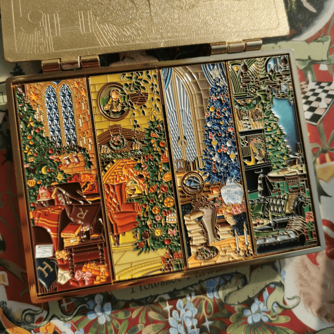 A golden gift box containing four rectangular soft enamel pins, each featuring a distinct design in a rustic style.