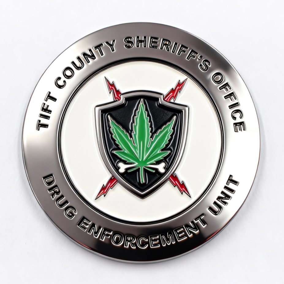 A funny challenge coin showing the Tift County Sheriff's Office emblem, with a cannabis leaf surrounded by a skull, crossbones, and red lightning. The design humorously amplifies the dangers of drugs with a satirical twist, combining law enforcement symbolism with danger and death motifs for a bold, ironic effect.