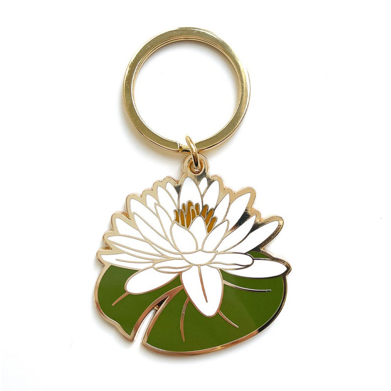 Gold-rimmed enamel keychain featuring a white water lily flower on green lily pad